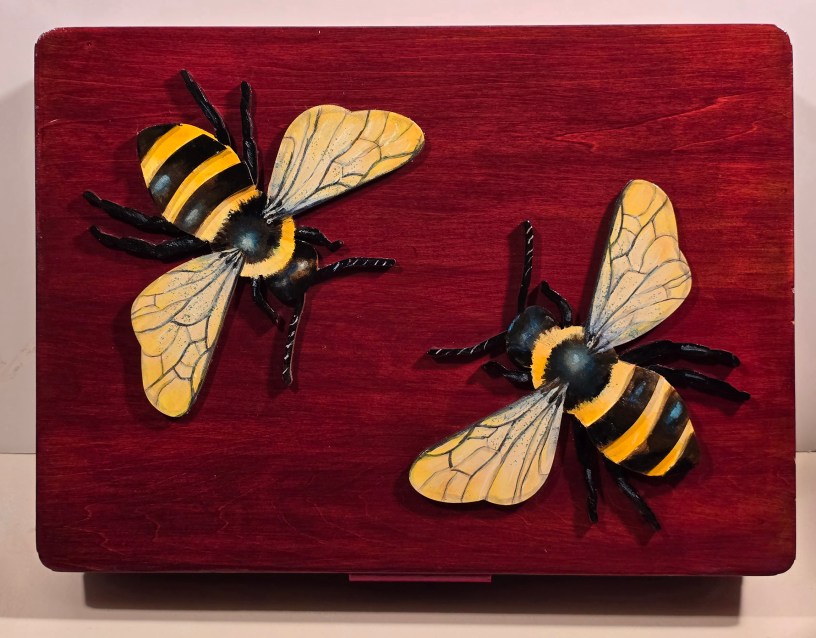Wooden box with two painted bees on top